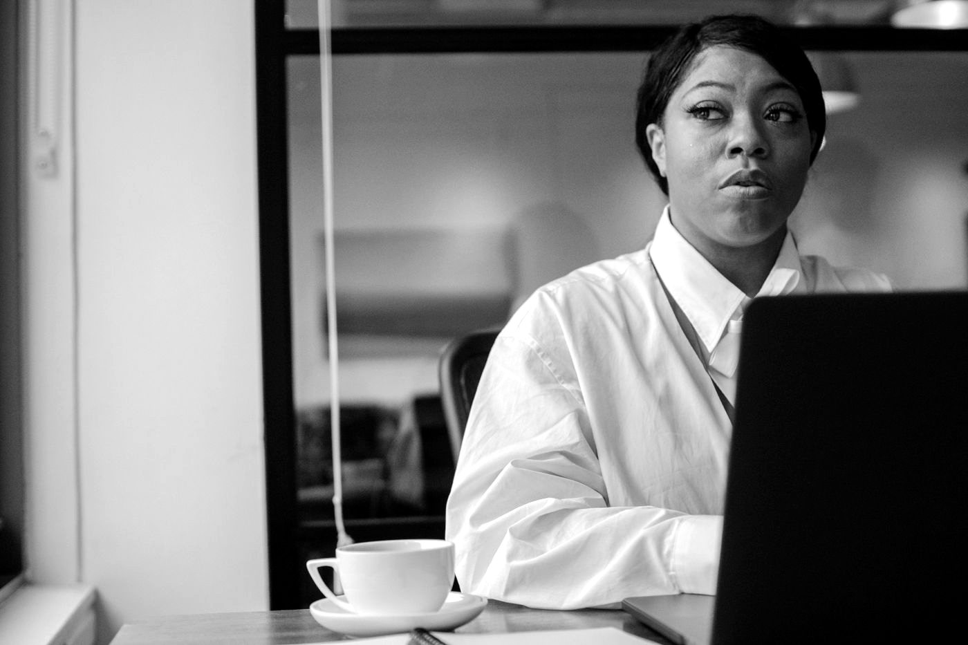 A businesswoman working at her laptop, in black and white